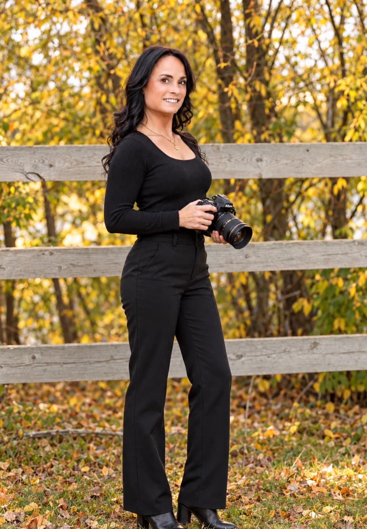 Ckenzie Hatton, St. Albert boudoir photographer, with her camera among autumn leaves