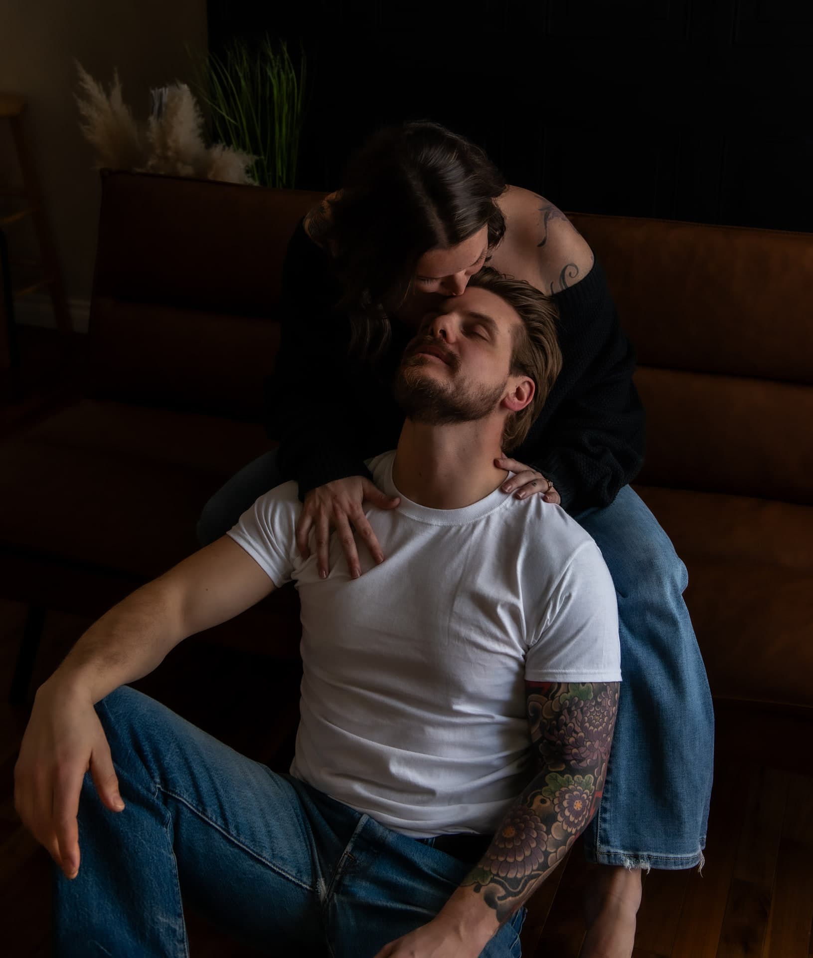 Couple in jeans and a white tee holding each other close